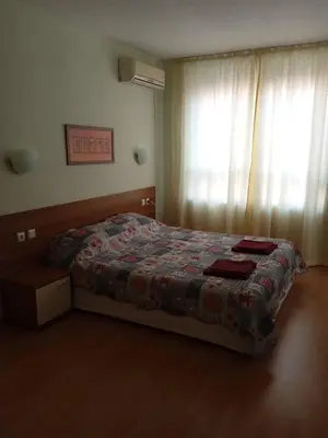 a bedroom with a bed with a blanket and a window at Big comfortable apartment with 2 bedrooms Pollo Resort Sunny Beach in Sunny Beach