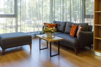 a living room with a blue couch and a table with flowers at Kraimorie Park in Burgas City
