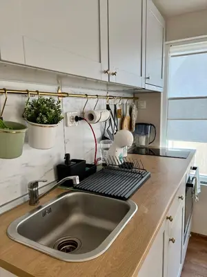 a kitchen with a stainless steel sink and white cabinets at Dockview atelier in Burgas City