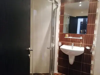 a bathroom with a sink and a shower with a mirror at Atlantis Resort D111 апартамент in Burgas City