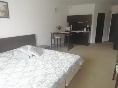 a bedroom with a white bed and a desk and a desk at Atlantis Resort D111 апартамент in Burgas City