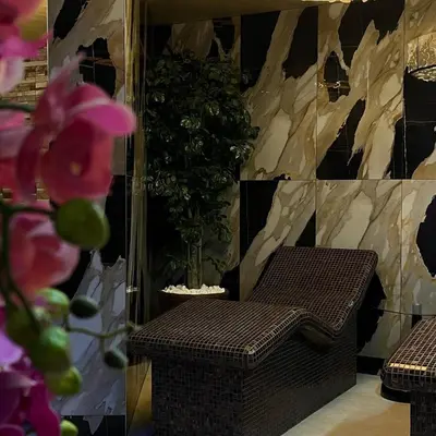 a wicker chair sitting in a room with a plant at Atlantis Resort D111 апартамент in Burgas City