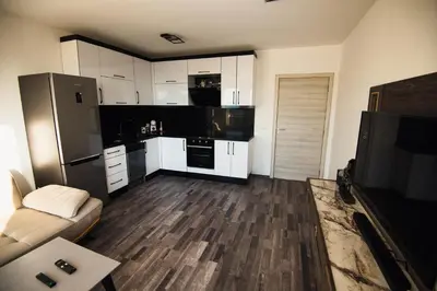 a kitchen with white cabinets and a black refrigerator at Modern Spacious 1BD Apartment for two in Nesebar by Flat Mаnаger in Nesebar