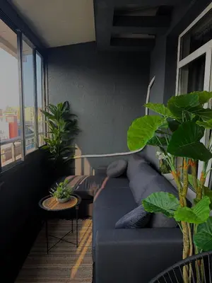 a living room with a blue couch and some plants at Bella Apartment - Holiday Complex Rainbow in Sunny Beach