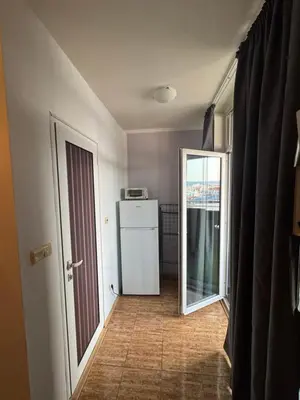 a hallway with a refrigerator and a door to a kitchen at Bella Apartment - Holiday Complex Rainbow in Sunny Beach