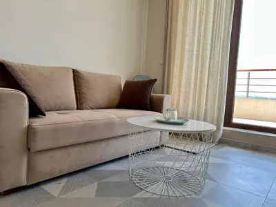 a living room with a couch and a table at Romantic Getaway 1-BD Apartment with Sea View by Flat Mаnаger in Sozopol