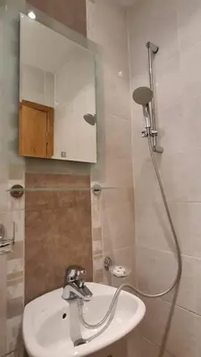 a bathroom with a sink and a shower with a mirror at Апартамент Лагуна Aйланд in Sozopol