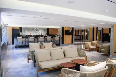 a lobby with a couch and chairs and a bar at Atliman Beach Resort in Kiten
