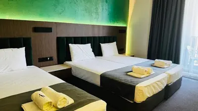 a hotel room with two beds with towels on them at Atliman Beach Resort in Kiten