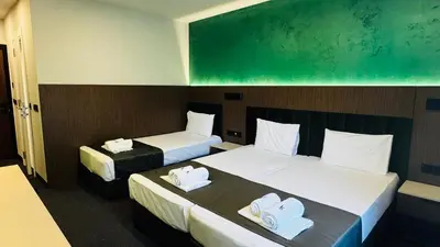 a room with two beds and a green board at Atliman Beach Resort in Kiten