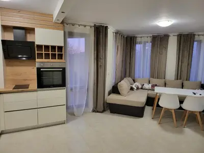 a kitchen and living room with a couch and a table at Apartment on the beach 2 in Ravda