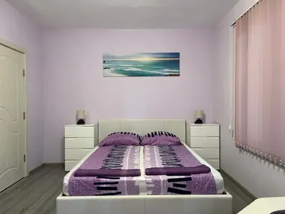 a bedroom with a bed with a purple blanket at Apartment Mihaela in Burgas City