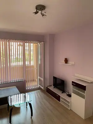 a living room with a table and a tv at Apartment Mihaela in Burgas City
