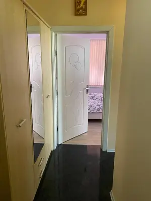 a hallway with a door and a mirror and a room at Apartment Mihaela in Burgas City