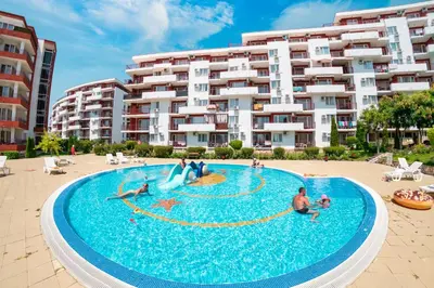 a group of people in a swimming pool in front of a building at Marina View Fort Beach in Sveti Vlas