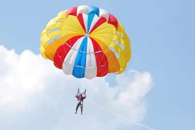 a man is riding a parachute in the sky at Marina View Fort Beach in Sveti Vlas