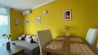 a yellow living room with a table and a couch at ANITA C 19 Apartment Sunny Beach in Sunny Beach