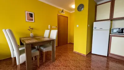 a kitchen with a wooden table and a refrigerator at ANITA C 19 Apartment Sunny Beach in Sunny Beach