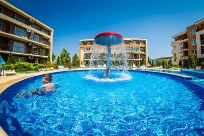 a child in a pool with a fountain at Orchid Fort Garden in Sunny Beach