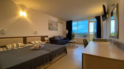 a bedroom with a bed and a table in a room at ESPERANTO 402 Large Studio Sunny Beach in Sunny Beach