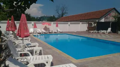 a swimming pool with lounge chairs and umbrellas at Studio N in Primorsko