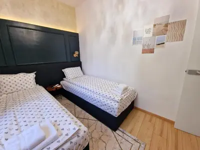 a bedroom with two beds and a tv on the wall at FS Apartments Varna - Beautiful apartment in the center of Varna in Varna City