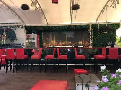 a restaurant with red chairs and a bar at Menada Admiral Plaza Apartaments in Sunny Beach