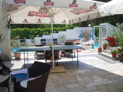 a patio with a table and an umbrella at Апартамент Холи in Sozopol