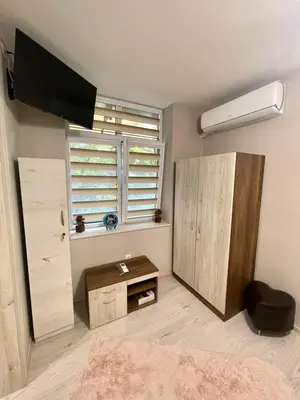 a bedroom with a tv and a desk and a window at Home in Varna City