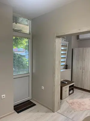 a living room with a large window and a desk at Home in Varna City