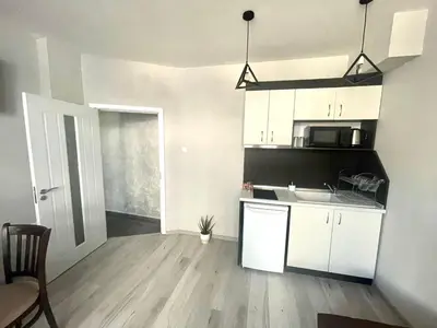 a kitchen with white cabinets and a sink in a room at Dream in Varna City