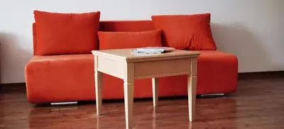 a orange couch with a table next to a side table at F 207 Primorsko del Sol - просторно студио с кухня in Primorsko