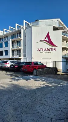 a parking lot with cars parked in front of a building at Apartment with green terrace in Burgas City