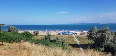 a beach with a bunch of umbrellas and the ocean at Apartment with green terrace in Burgas City