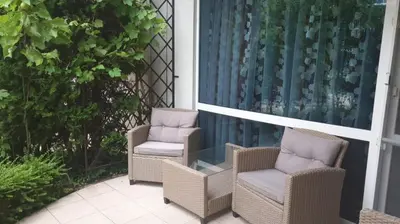 two chairs and a glass table on a patio at Apartment with green terrace in Burgas City