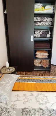 a bedroom with a bed and a closet with clothes at Apartment with green terrace in Burgas City