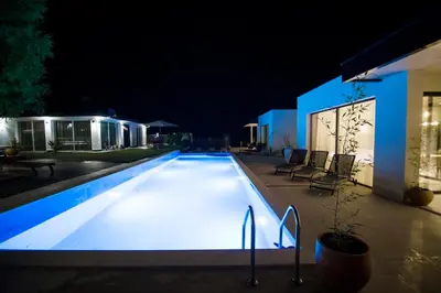 a swimming pool lit up at night at Luxury Villas Giardino Lozenetz in Lozenets