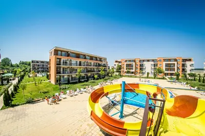 a playground with a slide in front of a building at Holiday Garden Resort in Sunny Beach