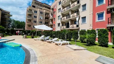 a swimming pool with lounge chairs and a building at Bratanov Vip Zone maisonettes 606 & 609 in Sunny Beach