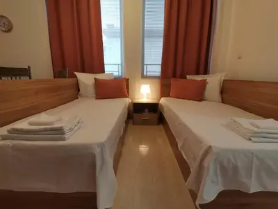 two beds in a room with red curtains at Апартамент Rose в местност Каваци, Созопол in Sozopol
