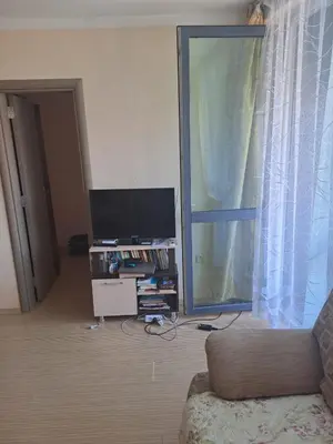 a living room with a couch and a tv and a window at SUNNY BEACH PLAZA Apartments in Sunny Beach