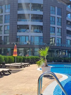 a building with a swimming pool in front of a building at SUNNY BEACH PLAZA Apartments in Sunny Beach