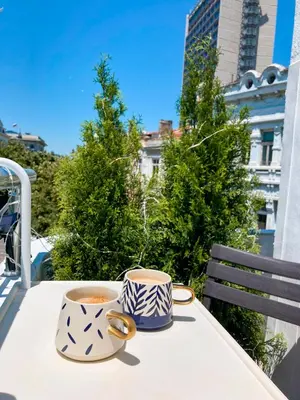 two cups of coffee sitting on a table on a balcony at Two Bedroom Apartment - Alexandrovska - Top Location - Central Bus, Train and Marine Stations, next to Sea Garden and Beach in Burgas City