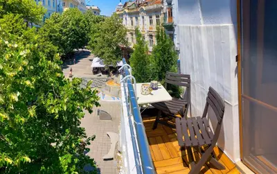 a balcony with a table and chairs on a balcony at Two Bedroom Apartment - Alexandrovska - Top Location - Central Bus, Train and Marine Stations, next to Sea Garden and Beach in Burgas City