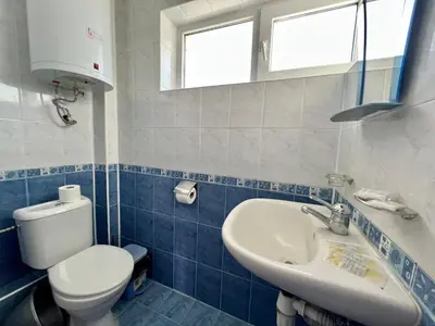 a blue and white bathroom with a toilet and a sink at Private One-Bedroom Apartment with Balcony in Sozopol by Flat Mаnаger in Sozopol