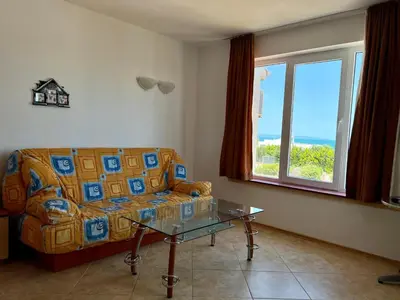 a living room with a couch and a table and a window at Private One-Bedroom Apartment with Balcony in Sozopol by Flat Mаnаger in Sozopol