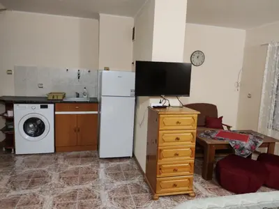 a kitchen with a refrigerator and a tv in it at Kamelya Guest Studio in Nesebar