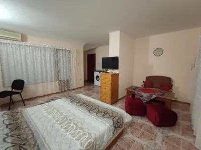 a bedroom with a bed and a desk and a tv at Kamelya Guest Studio in Nesebar
