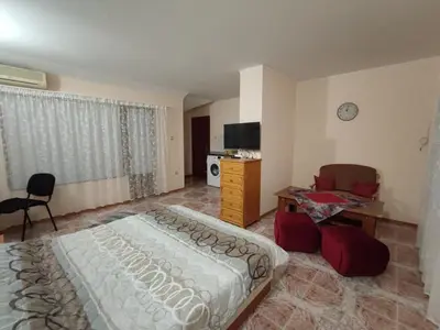 a bedroom with a bed and a desk and a tv at Kamelya Guest Studio in Nesebar