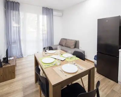 a living room with a wooden table and a refrigerator at Aleks Sunrise -Top Center ,Sea Garden in Burgas City